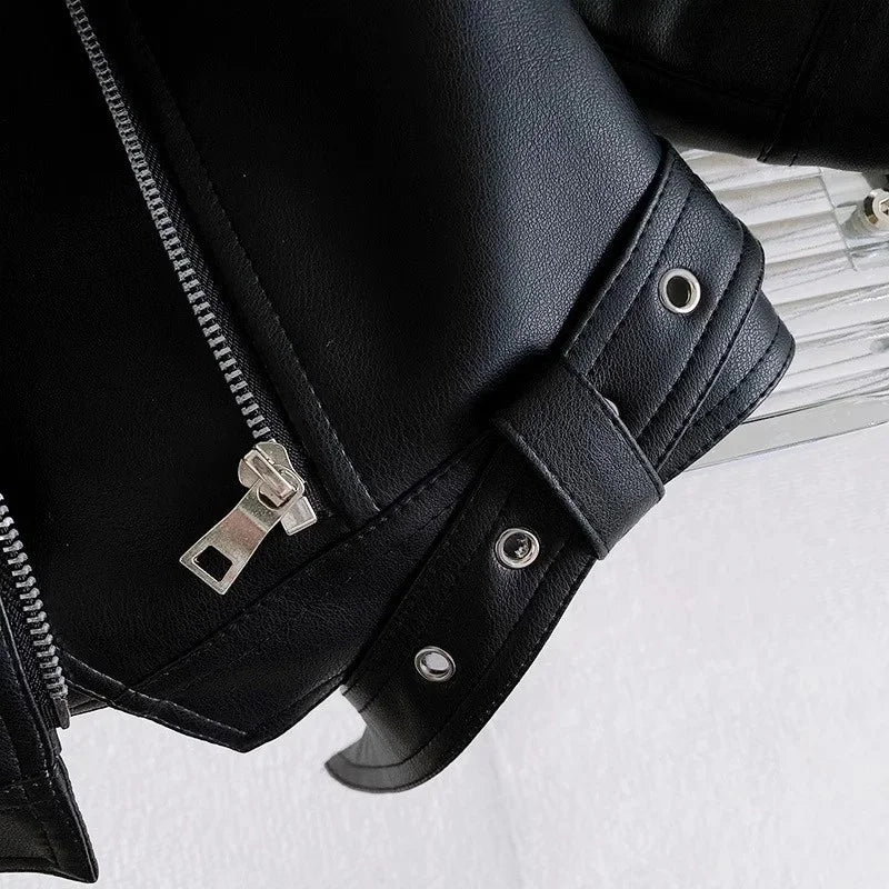 Close-up of a black faux leather zip-up jacket sleeve showing stitching and hardware.