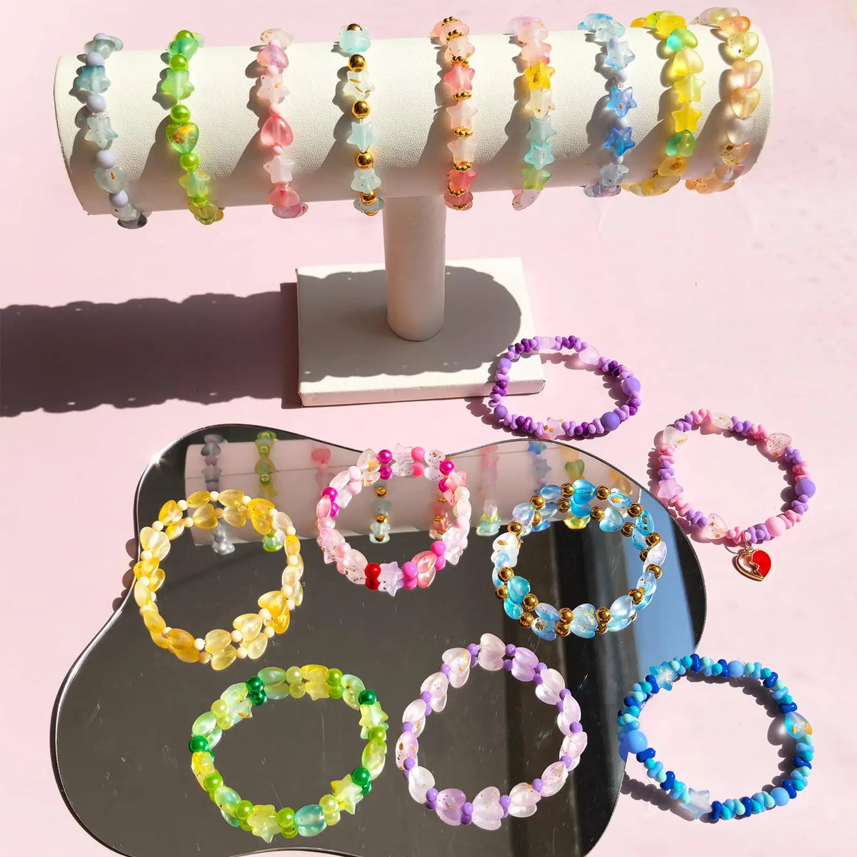 A display of various colored frosted golden foil acrylic beads on a white stand.