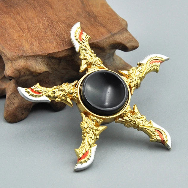 A gold-colored metal fidget spinner featuring a star design with rainbow accents and a black center.