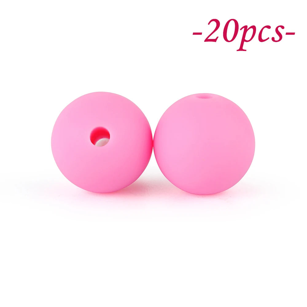 Two pink silicone beads, round and flexible, are shown against a white background.