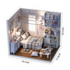 A wooden miniature dollhouse kit featuring furniture and decorative elements in a light blue and white theme.
