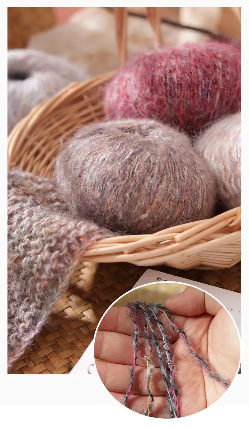 A close-up of soft, fuzzy alpaca blend yarn in various shades of gray and pink resting in a woven basket.