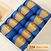 Box of blue Merino wool yarn balls with gold labels for knitting and crochet projects