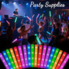 A close-up view of colorful LED foam glow sticks illuminating a crowd at a party.
