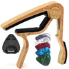 A wooden guitar capo set featuring a holder, picks, and a green capo.