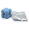 A pile of light blue candle dye chips next to a sealed plastic bag labeled Moon Blue.