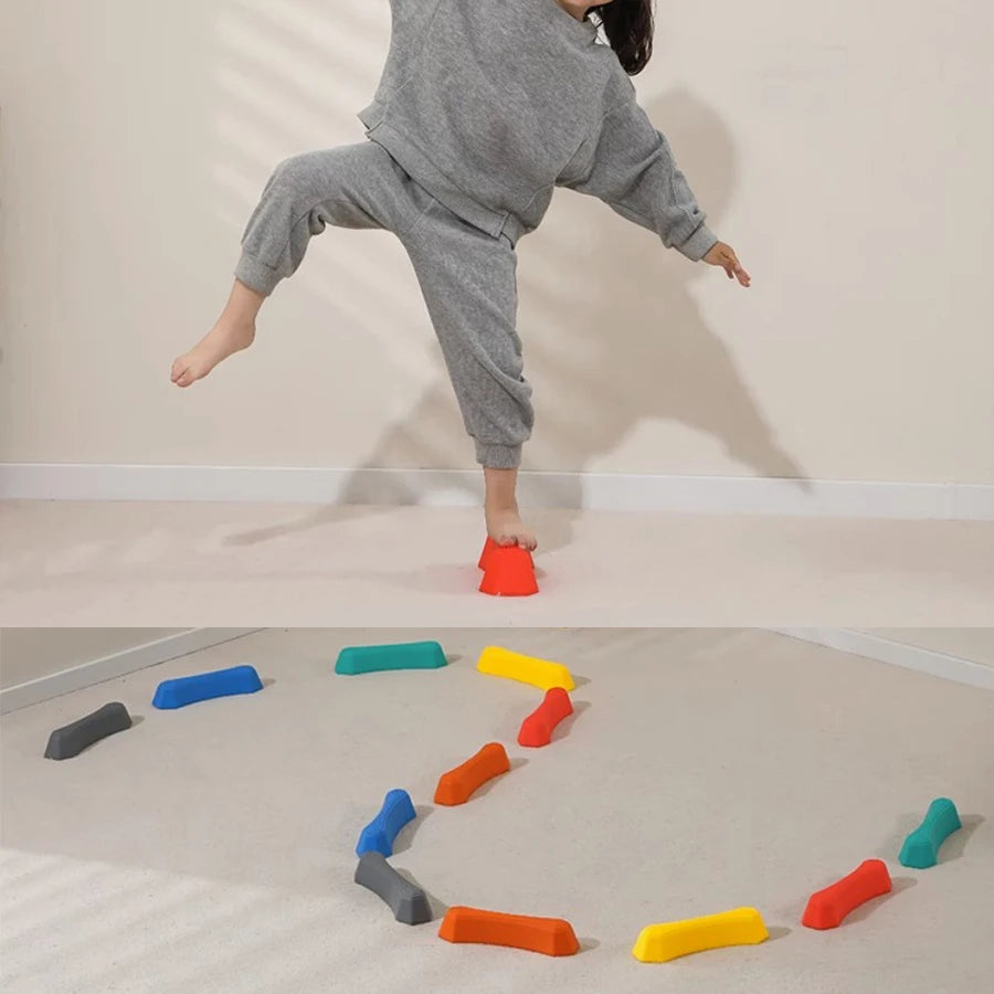 Rainbow sensory stepping stones in various colors arranged in a curved path on a light-colored floor.