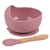 A pink BPA-free silicone snack cup with a lid and a matching spoon for babies and toddlers.