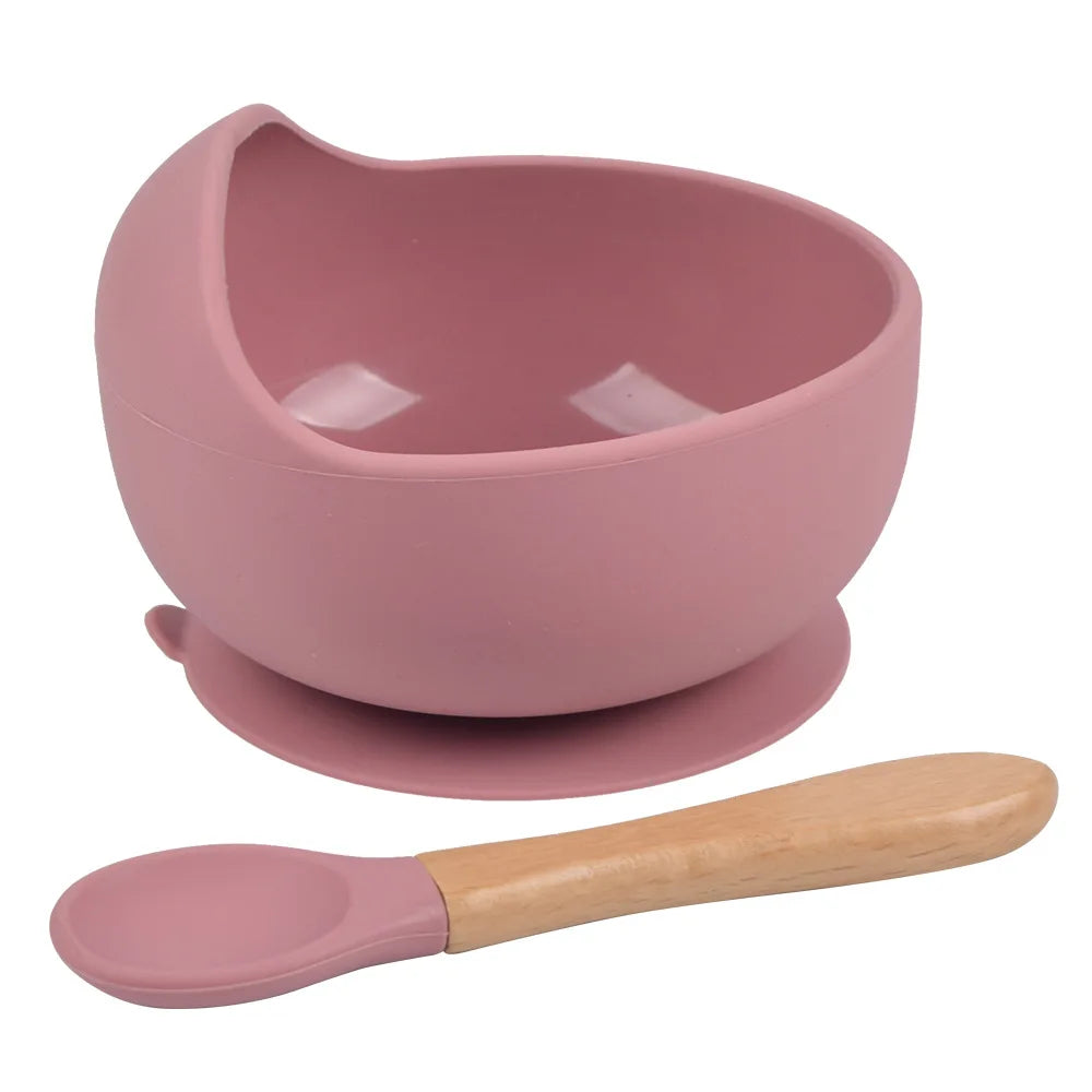A pink BPA-free silicone snack cup with a lid and a matching spoon for babies and toddlers.