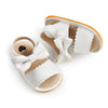 White baby summer sandals with a soft anti-slip sole and a decorative bowknot