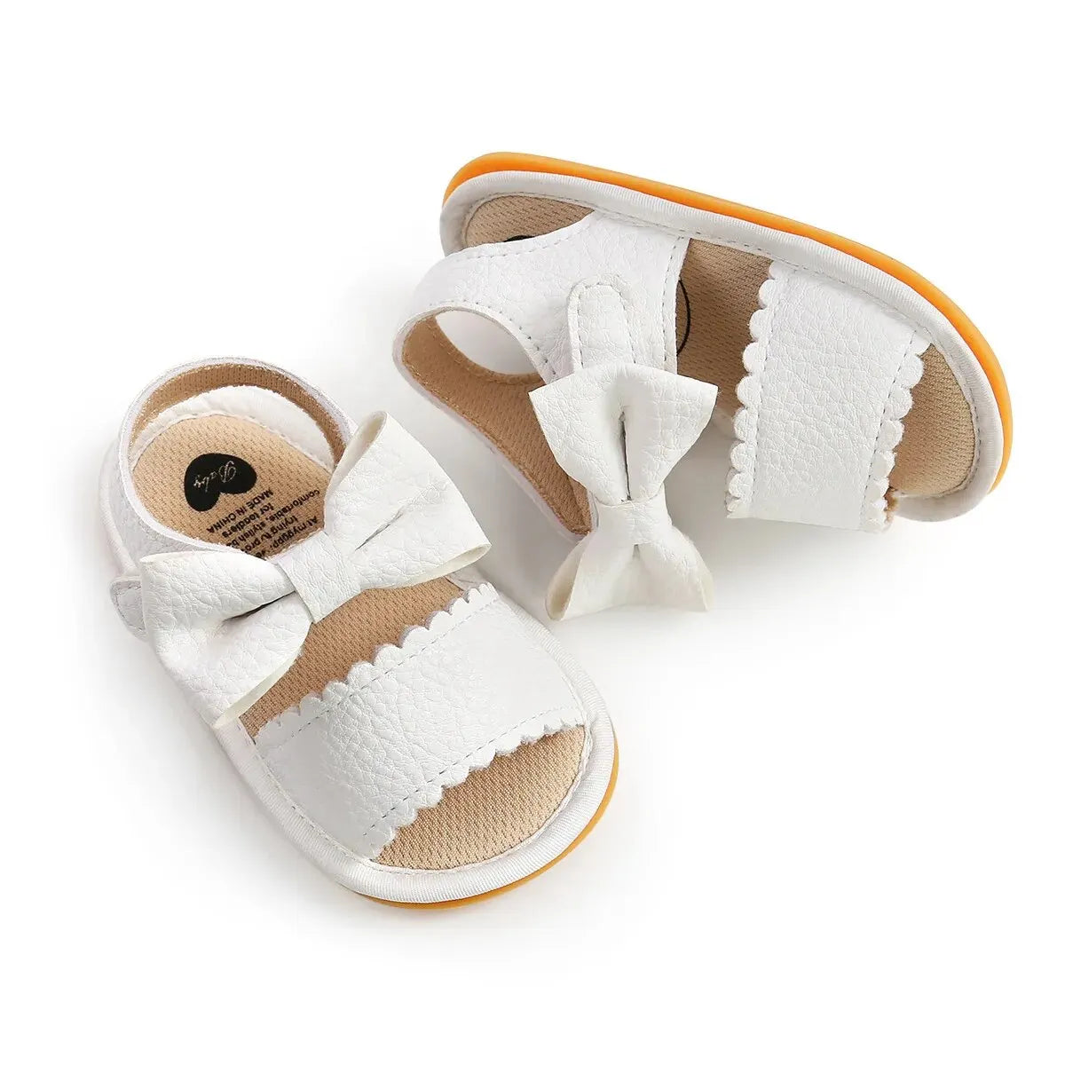 White baby summer sandals with a soft anti-slip sole and a decorative bowknot