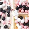 A collection of colorful and black silicone crafting beads arranged in a light wooden tray.