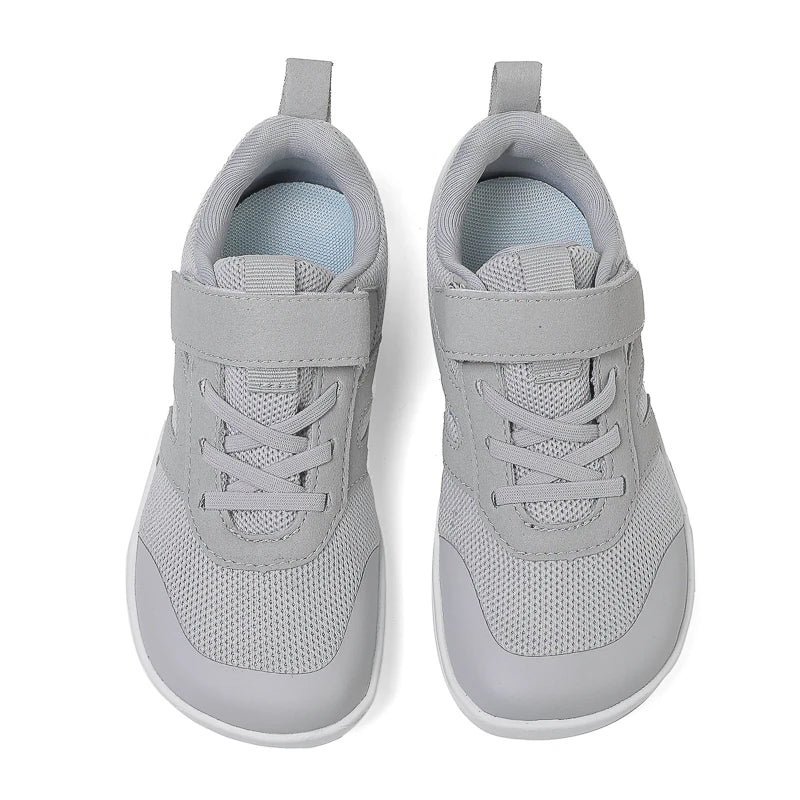 A pair of light gray minimalist barefoot sneakers for kids, shown from the top view.