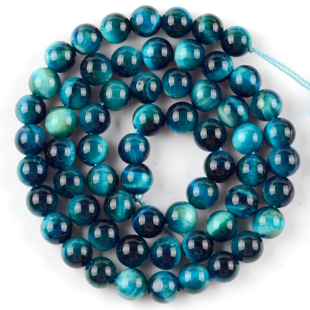 A strand of round, polished blue-green and deep blue natural sea sediment jasper and turquoise beads for jewelry making