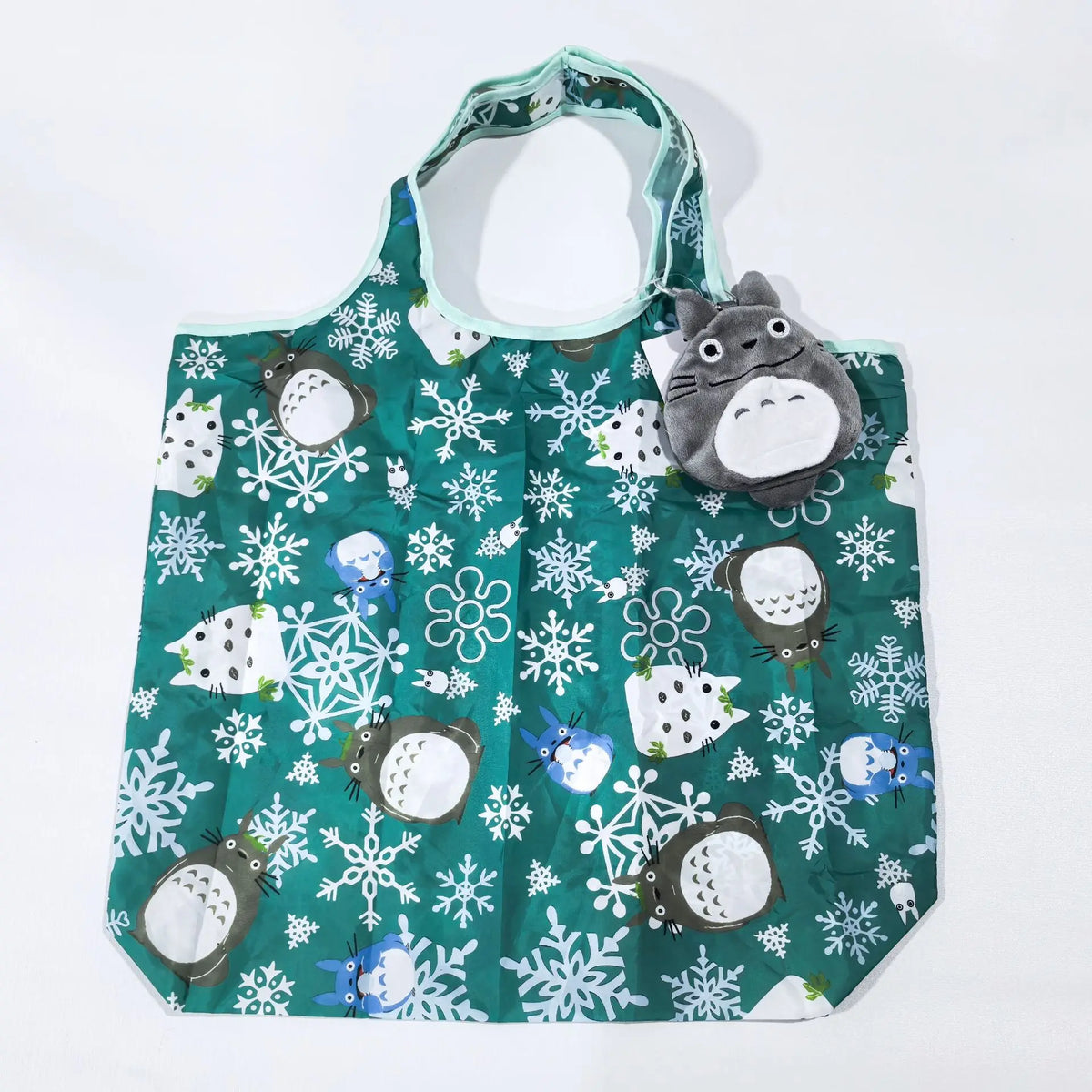 A green fabric storage bag featuring a white snowflake pattern and various gray and white animal figures.