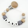 A personalized pacifier clip featuring wooden and silicone teething beads in various neutral tones.