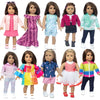 A collection of dolls wearing various colorful outfits including pink, purple, green, and blue tops and skirts.