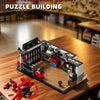 A detailed model of a garage building constructed from black and red blocks on a wooden table.