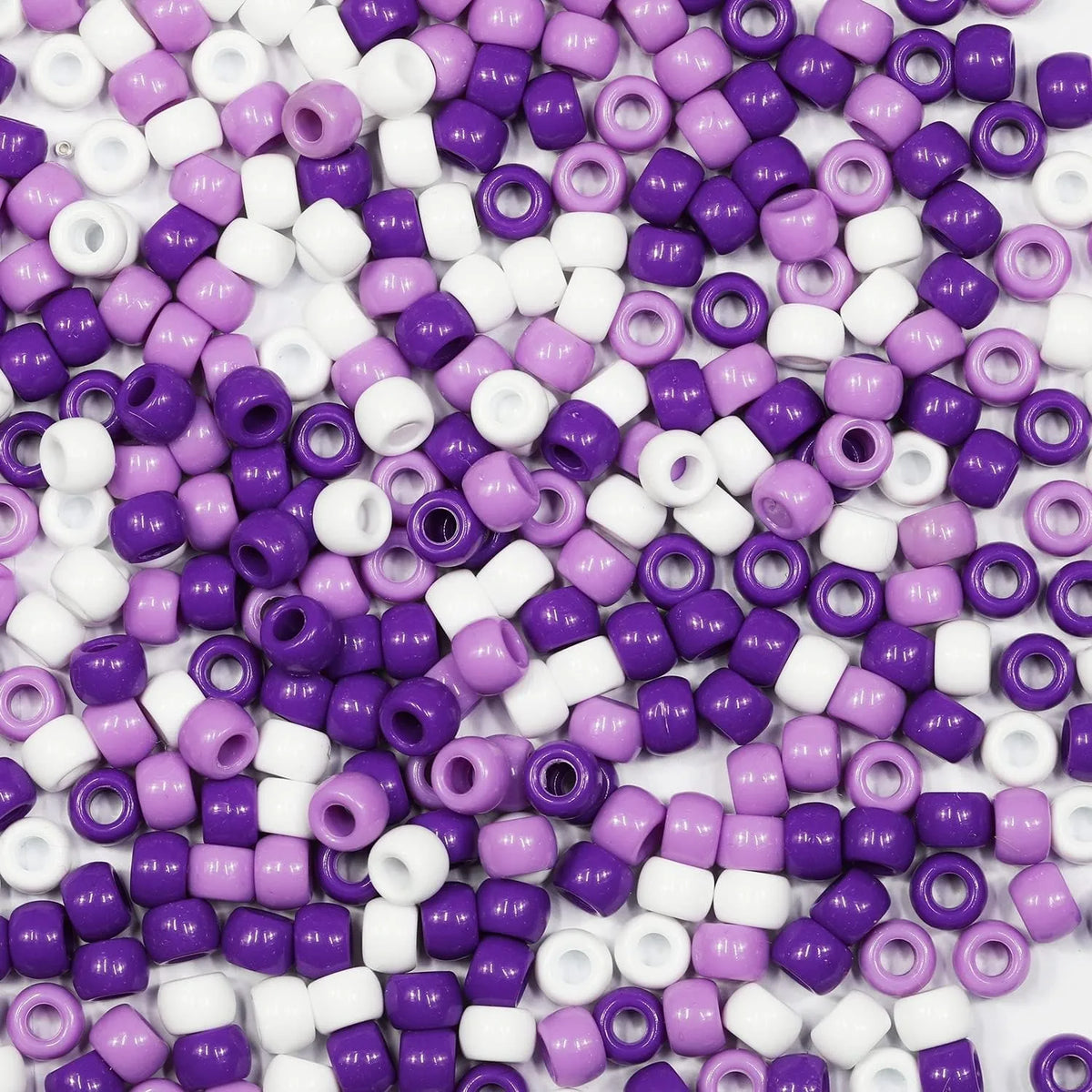 A pile of multicolor pony beads in purple and white, including various shapes like round and tube beads.