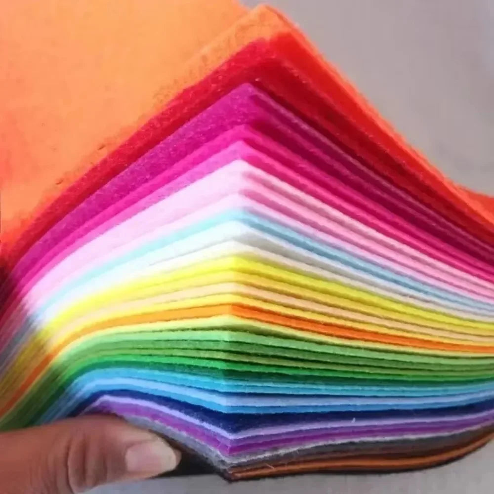 A stack of vibrant felt fabric sheets in a rainbow gradient, showing various colors like red, orange, yellow, green, blue, an