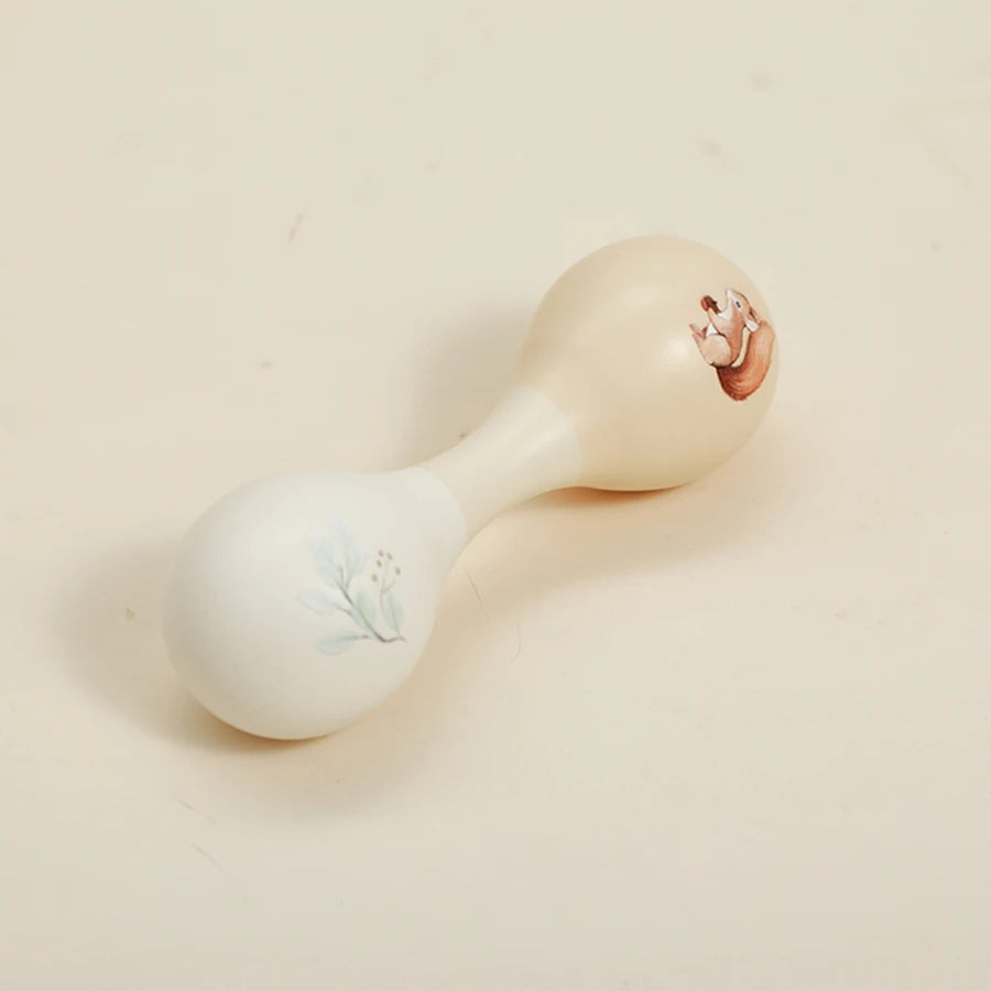 A light-colored wooden bear musical instrument, shaped like a horn, with a small floral design on the body.