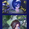 A blind box mini figure collectible featuring a character with blue hair and white bow, displayed on a clear stand.
