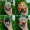 A set of four Demon Slayer anime action figures featuring characters like Tanjirou and Nezuko held in a hand.