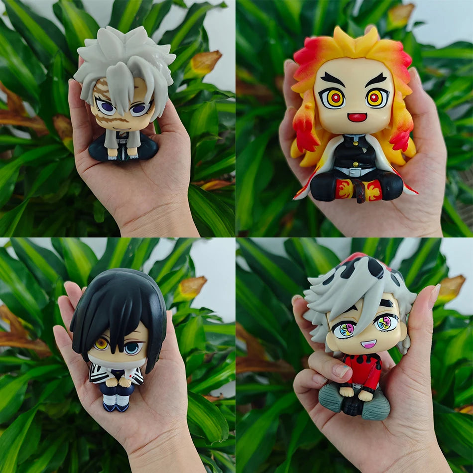 A set of four Demon Slayer anime action figures featuring characters like Tanjirou and Nezuko held in a hand.