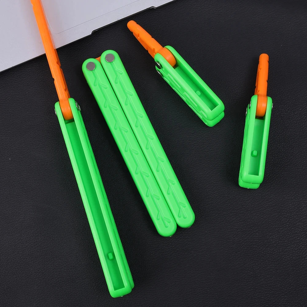 Three bright green and orange 3D printed butterfly knife fidget toys lying on a black surface.