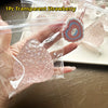 A hand holds a clear plastic bag containing a pink glitter strawberry squishy fidget toy and a heart-shaped charm.