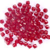 A pile of faceted red crystal bicone glass beads for jewelry making.