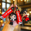 A keychain featuring a miniature figure of Michael Jackson with a metal buckle and attached to a leather strap.