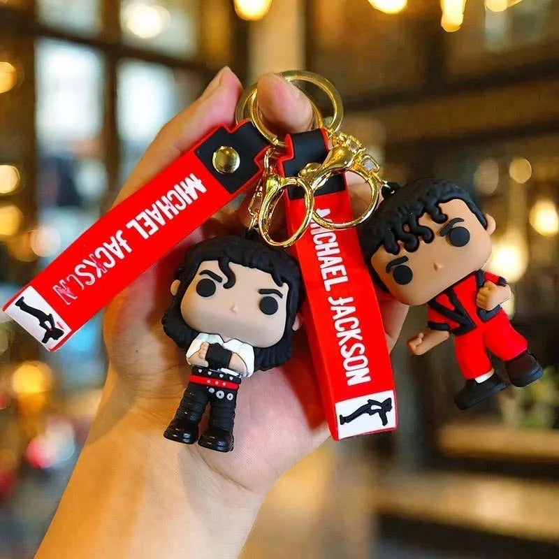 A keychain featuring a miniature figure of Michael Jackson with a metal buckle and attached to a leather strap.