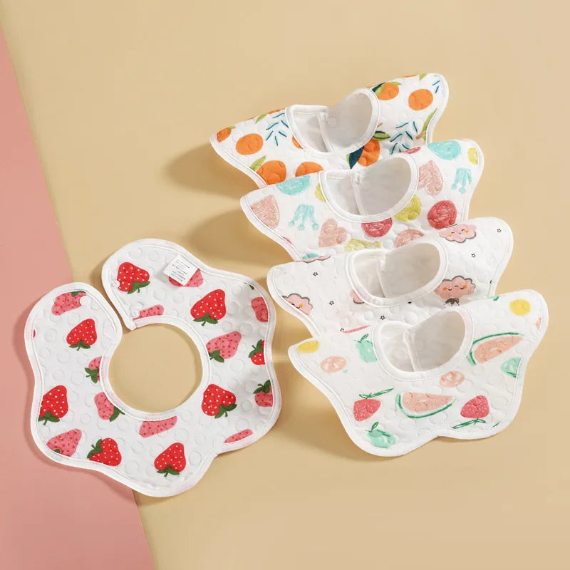 A set of three soft waterproof baby bibs featuring a sweet fruit pattern on a beige background.