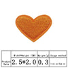 Un patch en forme de cœur orange brodé avec une texture de fil jaune.