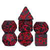 A set of seven black polyhedral dice with red markings, including a pyramid shape and a cube.
