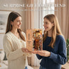 Two women smiling while holding a wooden book nook kit with LED lights for a surprise gift.