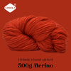 A ball of bright orange Merino wool yarn, 300g, is shown rolled up against a solid reddish-brown background.