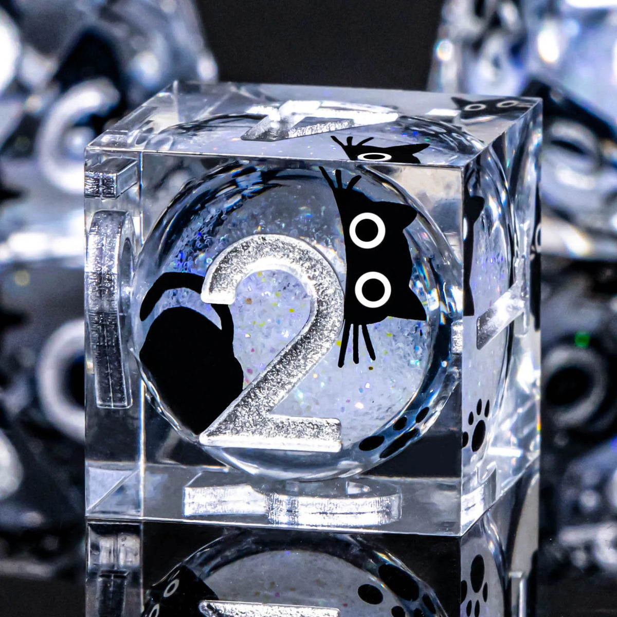 A clear resin die with a black cat silhouette and the number 2 is shown in a set.