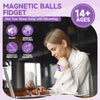 A woman is using a magnetic ball fidget toy on a laptop, demonstrating its use for stress relief.