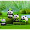 A set of adorable resin panda figurines in various poses and colors sitting on green grass.