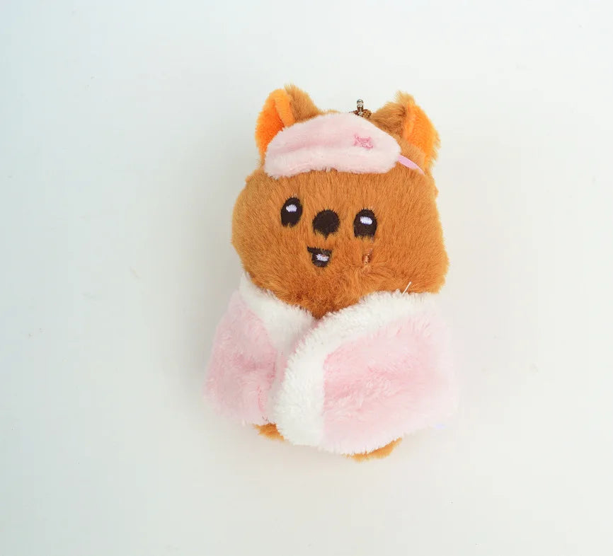 An adorable brown cartoon animal plush with pink ears and a pink and white fluffy garment.