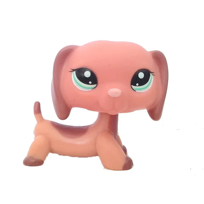 A pink dachshund bobblehead figurine with large green eyes and a cute expression.