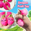 Hands hold and interact with bright pink dragon fruit toys, showing various squishy fruit shapes.