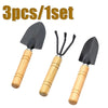 A set of three mini gardening tools with black blades and wooden handles.
