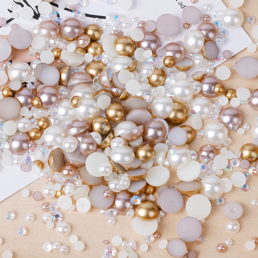 A scatter of mixed resin and glass pearls in various shades including pink, gold, and white on a wooden surface.