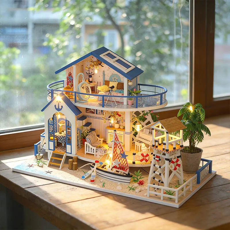 A detailed miniature dollhouse kit of a seaside beach house with an LED light, featuring wooden structures and nautical decor