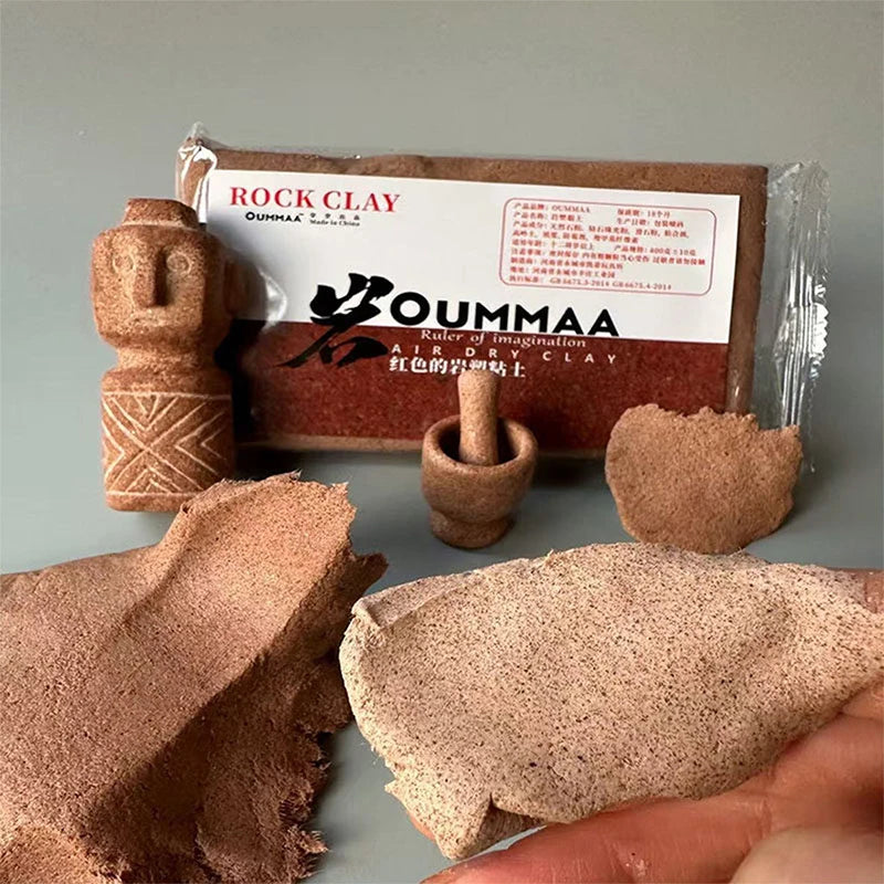 A box of ROCK CLAY modeling clay is shown next to a hand-formed piece of the clay.
