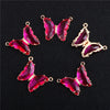 A set of five pink and magenta crystal butterfly charm beads for jewelry making