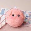 A pink squeaky plush pig keychain with black eyes is displayed inside a pink wire cage.